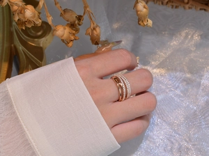Detail view of multi-layered rose gold ring with sparkling pavé stones on a model