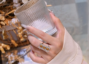 Detailed view of wide 925 sterling silver ring with three round yellow gemstones on a model