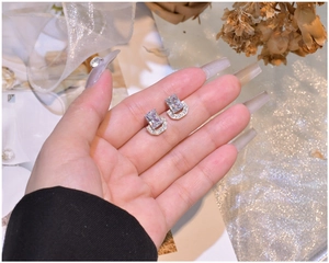 Detailed close-up of U-shaped 925 silver stud earrings with emerald cut zircon stones