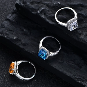 Radiant cut 925 sterling silver rings with colorful stones on dark stone background