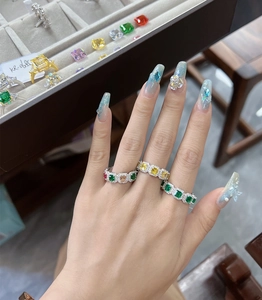 Detailansicht von bunten Ringen mit Smaragdschliff-Edelsteinen und Mikro-Pavé-Diamanten