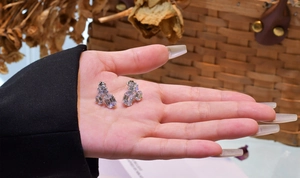 Detailed close-up of 925 sterling silver studs with emerald-cut cubic zirconia stones