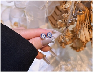 Macro view of S925 sterling silver evil eye stud earrings with blue cubic zirconia