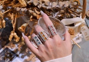 Detailed shot of three S925 silver bridge rings set with pink, yellow, and blue gems