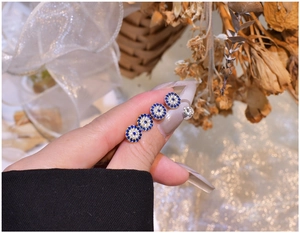 Close-up of S925 sterling silver blue zircon Evil Eye stud earrings with gold plating