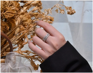 Détail d'une bague large en argent 925 avec plusieurs rangées de zircons sur un modèle
