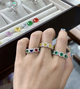Makro-Detail von Silberringen mit bunten Smaragdschliff-Edelsteinen und Halo-Pavé-Diamanten