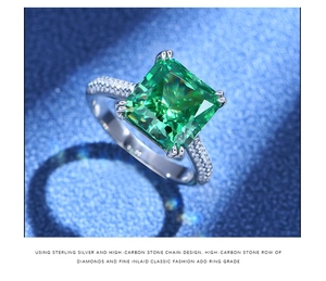 Makroaufnahme eines grünen Rings im Smaragdschliff mit Krallenfassung aus 925er Silber