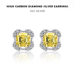 Detailed macro view of radiant yellow emerald-cut carbon diamond stud earrings with silver halo
