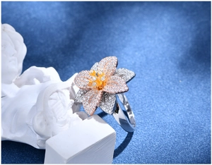 Dettaglio macro di un anello a fiore in argento 925 con zirconi e placcatura tricolore