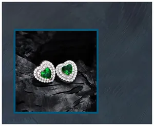 Macro detail of heart-cut emerald studs in S925 silver with double-layered halo crystals