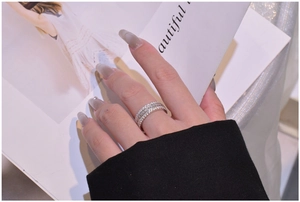 Gros plan détaillé d'une bague à trois rangées en argent sterling sertie de diamants