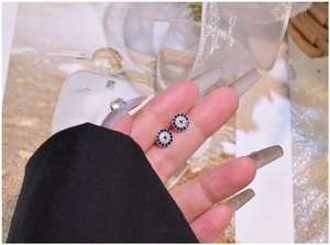 Detailed view of gold S925 silver evil eye stud earrings with blue and white zircons