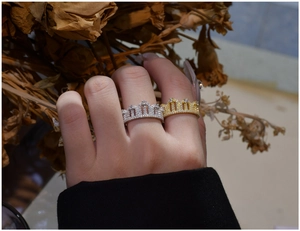 Detailed comparison of gold and silver crown rings with crystals worn on fingers
