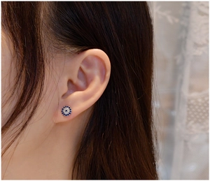 Close-up of S925 sterling silver mini evil eye stud earring with blue zircon on ear