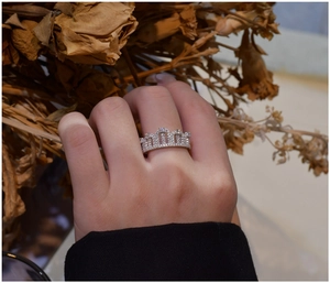 Detail of 925 silver crown ring with sparkling white cubic zirconia on a female finger