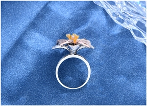 Dettaglio ravvicinato di un anello a fiore in argento S925 con petali a tre strati pavé