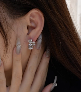 Macro shot of 925 silver stud earrings with emerald-cut cluster clear cubic zirconia
