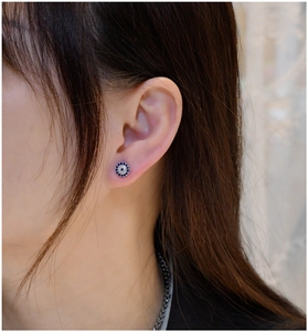 Close-up of S925 sterling silver blue and white zircon round stud earrings on female ear