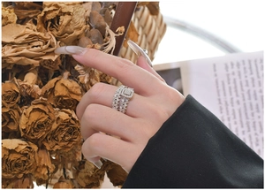 Close-up of S925 silver rings with pavé cubic zirconia worn on a model hand