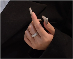 Gros plan d'une bague en argent à trois rangées avec zircons baguette et ronds au doigt