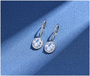 Macro shot of 925 silver lever-back earrings with oval halo design and clear gemstones