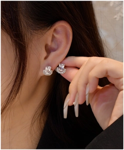 Close-up of 925 sterling silver U-shaped earrings with emerald cut cubic zirconia crystals