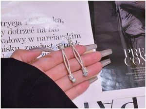 Detailed view of sterling silver long tassel earrings featuring micro-pave zircon crystals