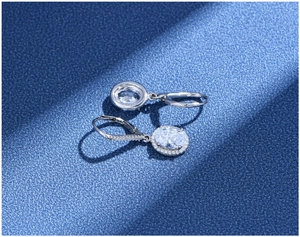 Macro view of 925 silver oval-cut halo earrings with lever-back closure on blue background