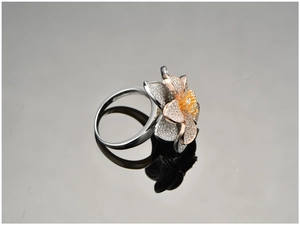 Close-up of tricolor floral ring with layered petals and pavé-set cubic zirconia