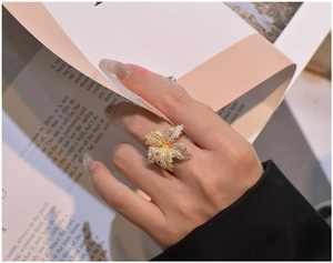 Macro view of a large two-tone butterfly ring set with pavé cubic zirconia on fingers