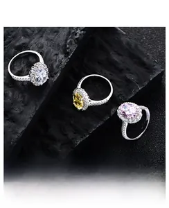 Macro detail of oval cut pink, yellow, and clear 5.6ct rings on dark rock base