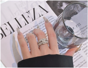 Macro detail of a silver S925 pave set stacking ring featuring a square center stone