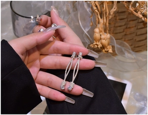 Macro view of long 925 silver tassel earrings with micro-pave cubic zirconia crystals