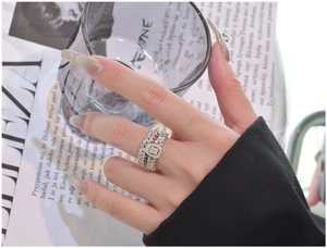 Close-up of S925 silver stacked rings with geometric pave crystals on a model hand