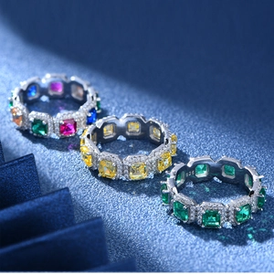 Drei 925 Silberringe mit Smaragdschliff und bunten Edelsteinen auf blauem Glitzergrund