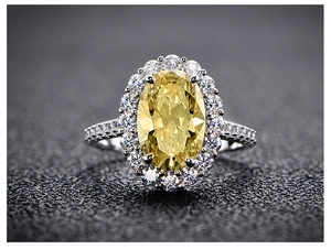 Macro shot of 5.6 carat oval cut yellow diamond ring with a halo of white pavé diamonds