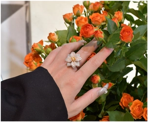 Dettaglio dell'anello a fiore in argento S925 con micro diamanti e pietra gialla