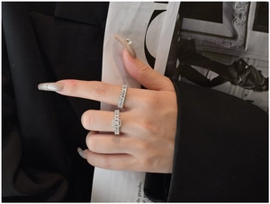 Detail shot of stacked S925 silver rings with square cut cubic zirconia on a model hand