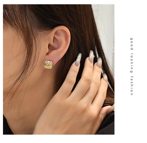 Close-up of 925 silver stud earrings with a 7x7mm yellow cushion-cut diamond-like gem