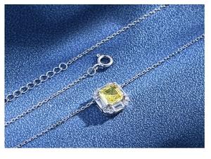 Vue macro d'un collier en argent 925 avec un pendentif carré serti d'une pierre jaune