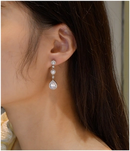 Macro detail of S925 silver pear-cut drop earrings with sparkling cubic zirconia pavé