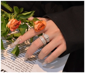 Close-up of 925 sterling silver stacked ring set with emerald cut zircon on newspaper