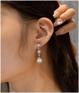 Macro detail of S925 silver pear-cut drop earrings with sparkling pavé cubic zirconia