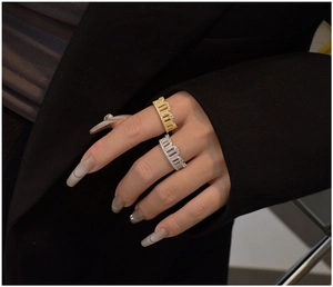 Detail shot of gold and silver crown rings with pavé set zircon stones on a model's hand