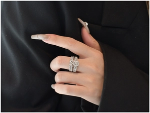 Close-up of stacked S925 silver rings with emerald cut cubic zirconia on a hand