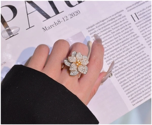 Close-up of three-tone floral ring with micro-pave diamonds and yellow center stone