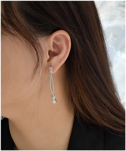 Macro detail of silver dangling twist earrings featuring pavé micro-set diamonds for women