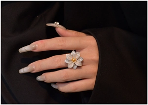 Dettaglio dell'anello a fiore in micro pavé con zircone giallo indossato sulla mano
