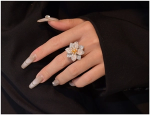 Primo piano di un anello a fiore di lusso con micro-cristalli e cuore di gemma gialla
